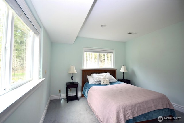 bedroom with light colored carpet, visible vents, and baseboards