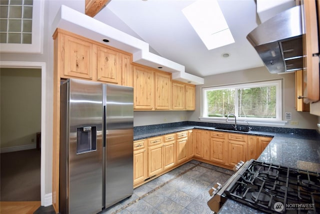 kitchen featuring a sink, stainless steel appliances, lofted ceiling with skylight, and light brown cabinetry