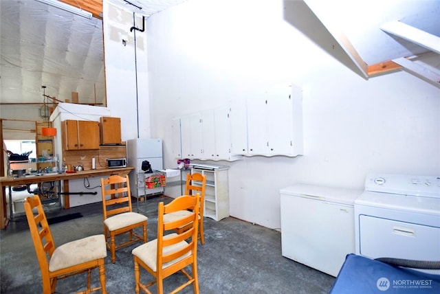 interior space with a workshop area, separate washer and dryer, freestanding refrigerator, and white fridge