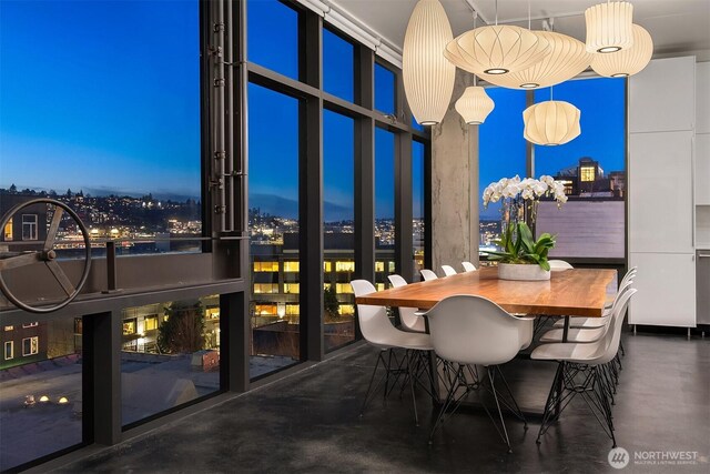 dining room featuring a city view, concrete floors, and expansive windows