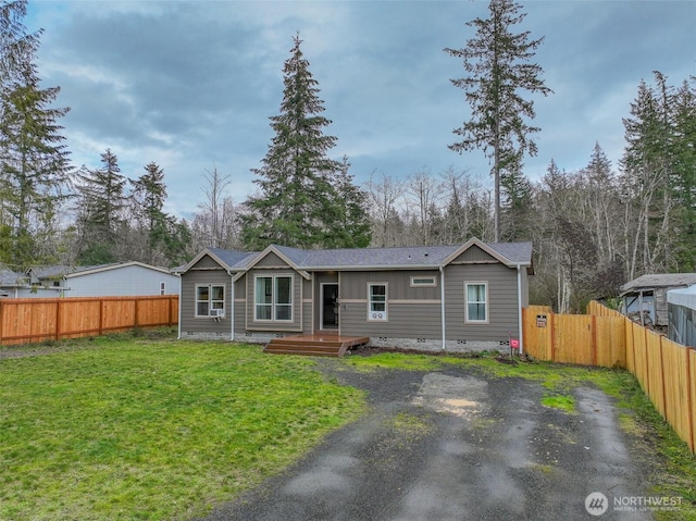 view of front of home with crawl space, a front lawn, and fence