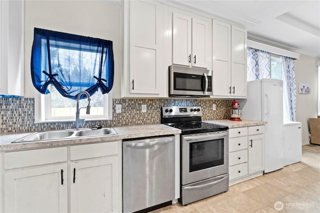 kitchen featuring a sink, decorative backsplash, white cabinetry, and stainless steel appliances