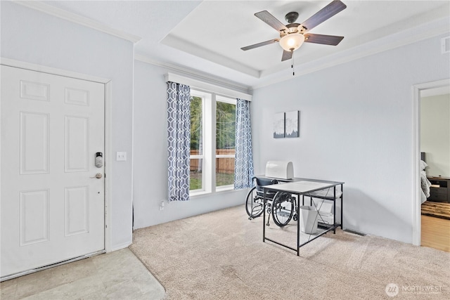 office with visible vents, a ceiling fan, carpet, crown molding, and a raised ceiling