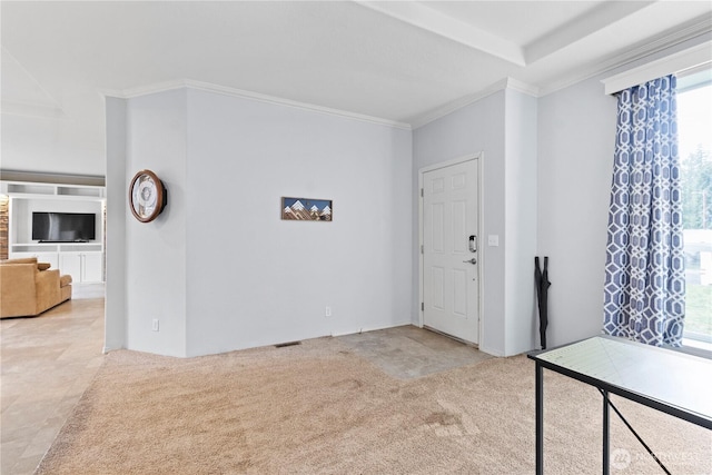 foyer entrance featuring visible vents, carpet floors, and ornamental molding