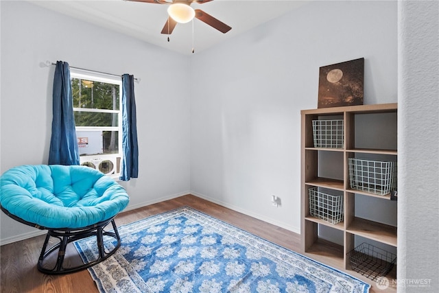 sitting room featuring wood finished floors, a ceiling fan, and baseboards