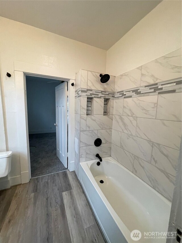 bathroom featuring shower / bath combination, baseboards, toilet, and wood finished floors