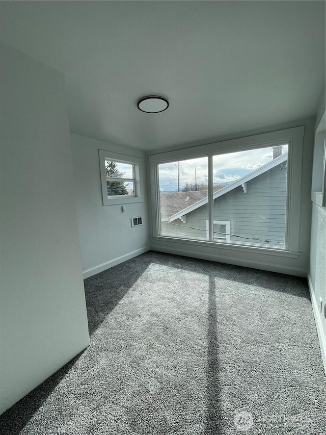 spare room with baseboards and carpet