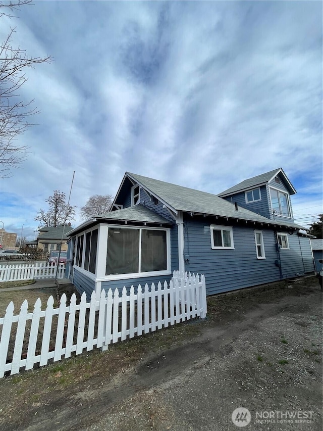 view of front of house with a fenced front yard and a sunroom