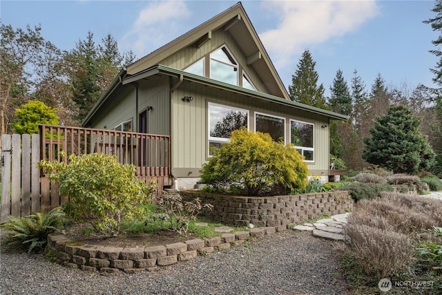 view of property exterior featuring a deck and fence