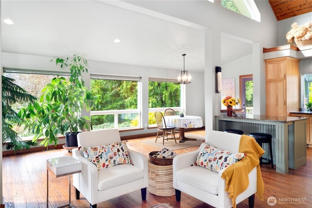 living area featuring an inviting chandelier, recessed lighting, wood finished floors, and lofted ceiling