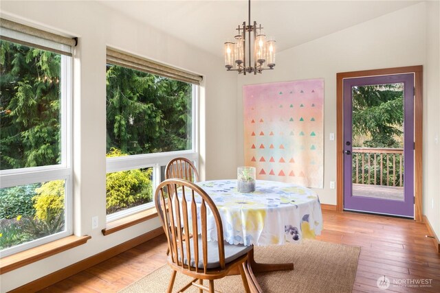 dining area with baseboards, wood-type flooring, and a chandelier