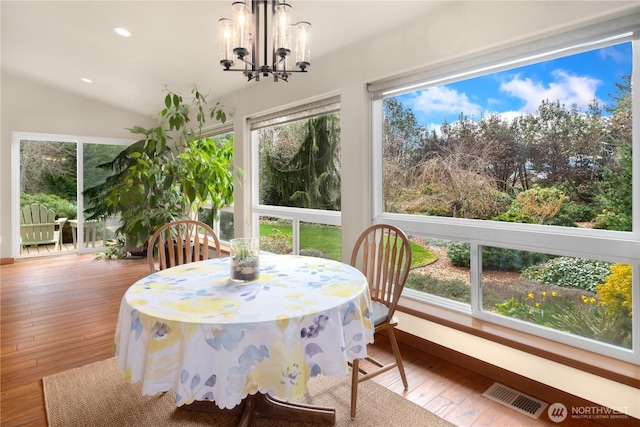 sunroom / solarium with a chandelier, visible vents, and lofted ceiling