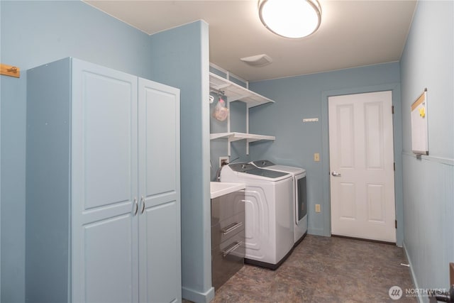 clothes washing area featuring baseboards, laundry area, and washer and clothes dryer