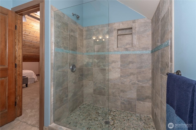 ensuite bathroom featuring a stall shower, ensuite bath, and vaulted ceiling