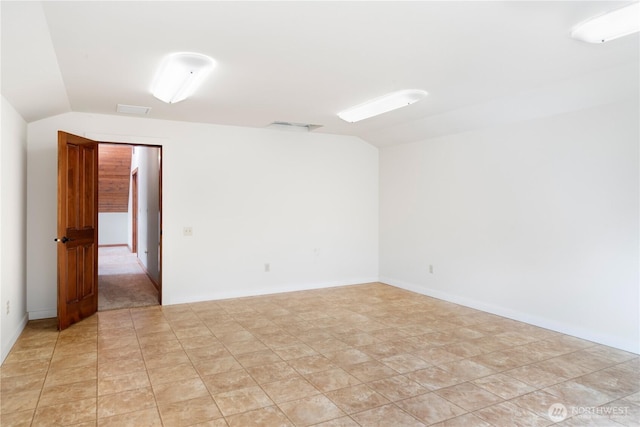 spare room featuring lofted ceiling and visible vents