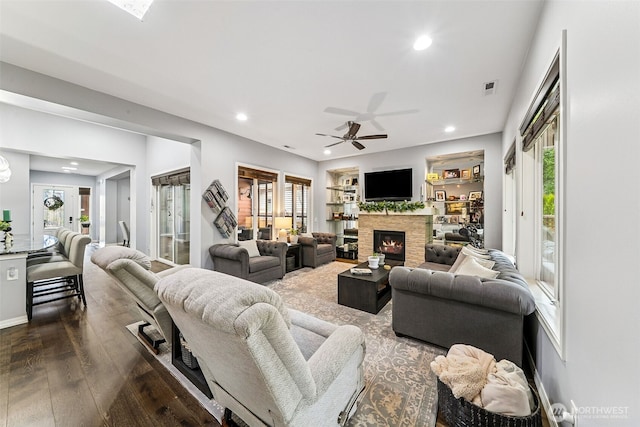 living room with visible vents, recessed lighting, a fireplace, dark wood-type flooring, and a ceiling fan