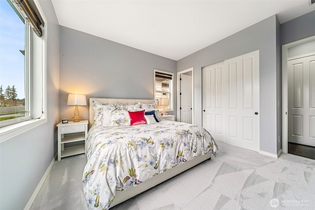carpeted bedroom with baseboards and a closet