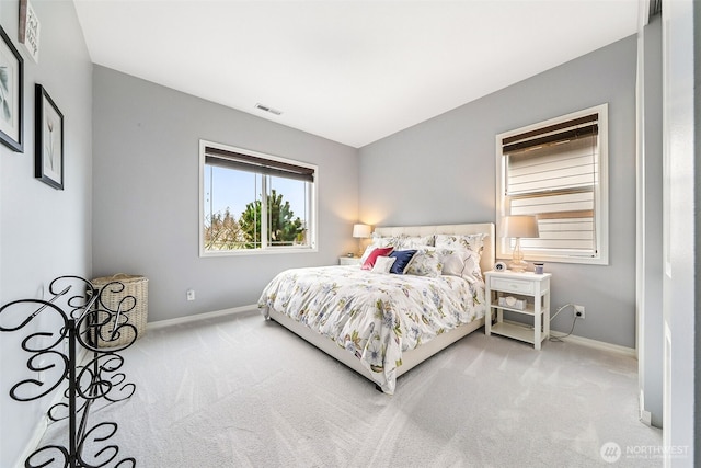 carpeted bedroom with visible vents and baseboards