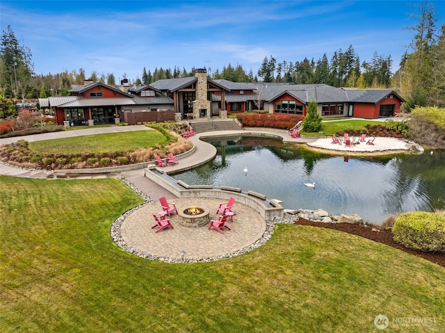 exterior space with a lawn, a chimney, and an outdoor fire pit