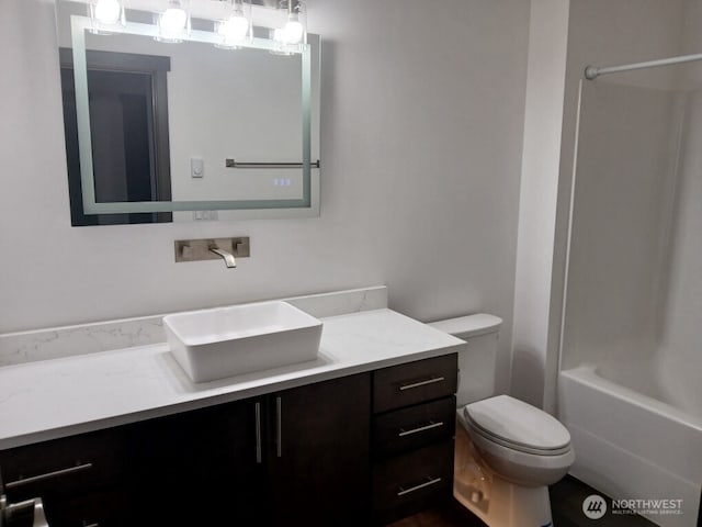 full bath featuring washtub / shower combination, toilet, and vanity