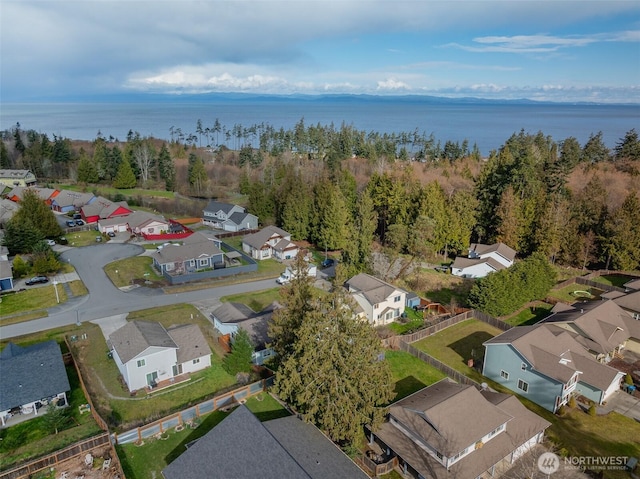 aerial view with a residential view, a wooded view, and a water view