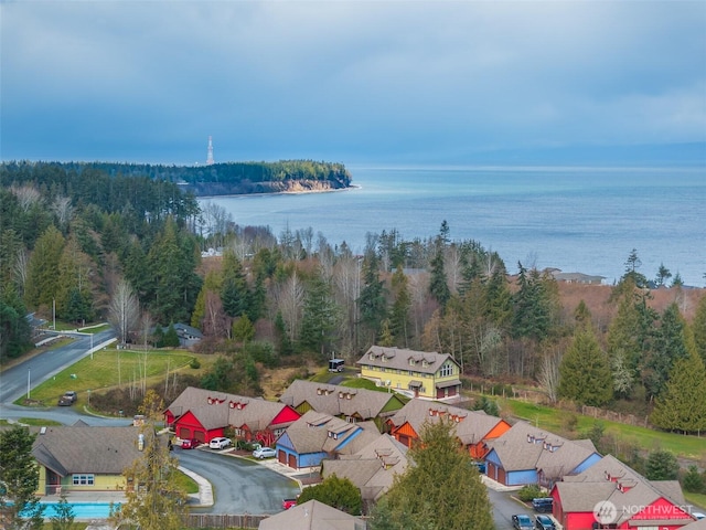 birds eye view of property with a water view and a wooded view