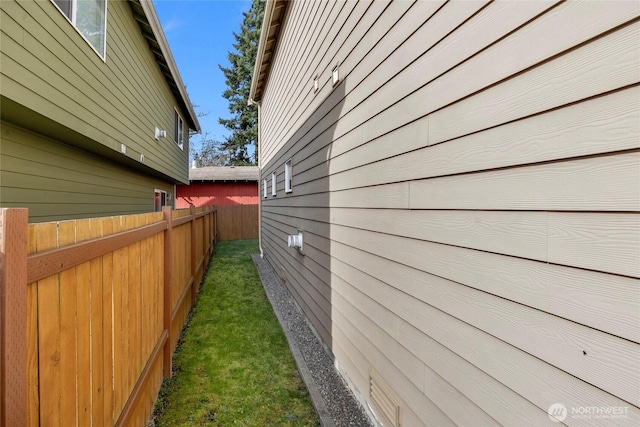 view of property exterior with a yard and fence