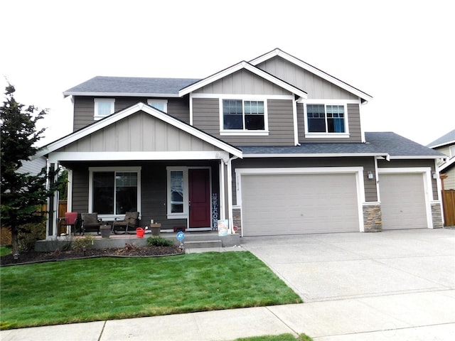 view of front of property featuring a front lawn, stone siding, board and batten siding, covered porch, and concrete driveway