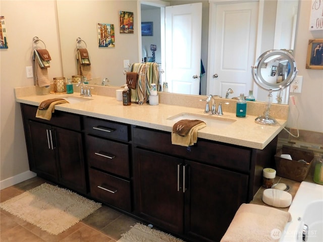 full bath featuring a sink, baseboards, and double vanity