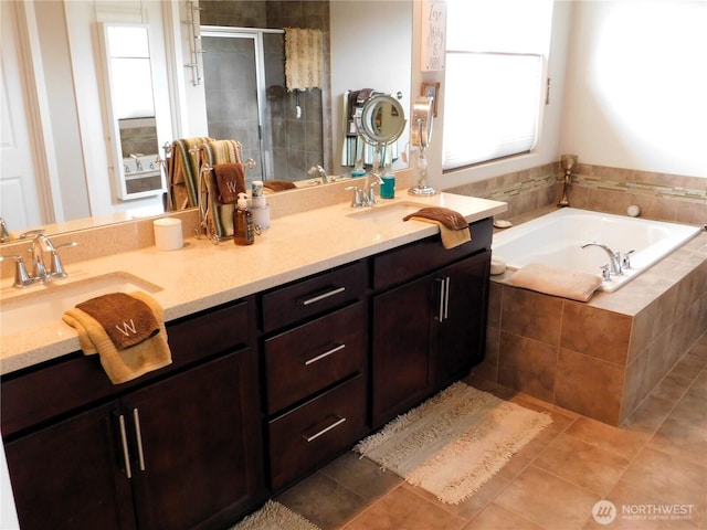 bathroom featuring a shower stall, a bath, tile patterned floors, and a sink