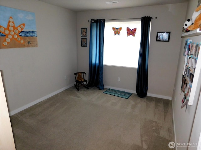 carpeted spare room featuring visible vents and baseboards