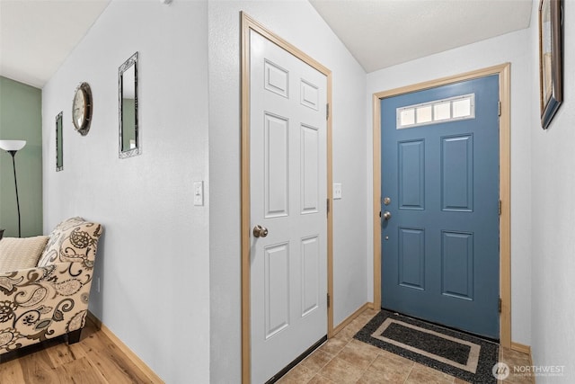 foyer featuring light wood finished floors and baseboards