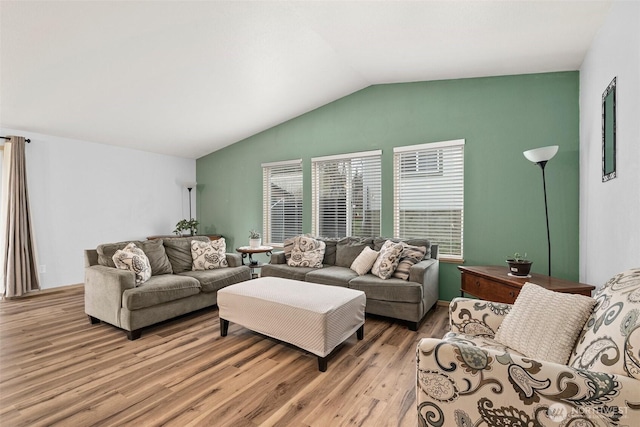 living area with lofted ceiling, light wood-style flooring, and a wealth of natural light