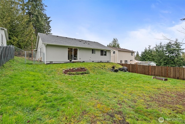 rear view of property featuring crawl space, a yard, and a fenced backyard