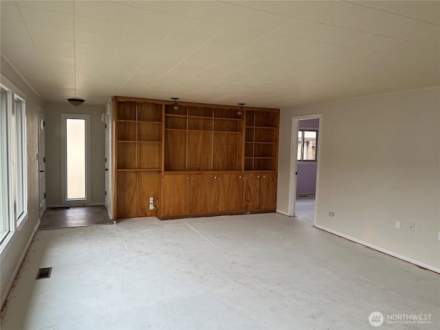 unfurnished living room featuring baseboards, concrete floors, and visible vents