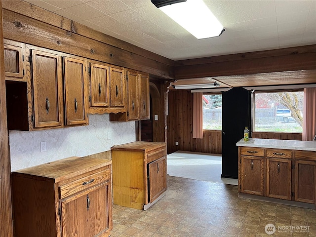 kitchen with wooden counters, brown cabinets, tile patterned floors, and wooden walls