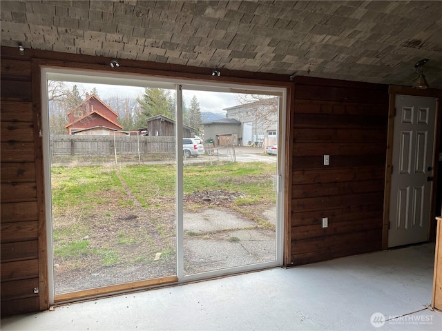 doorway featuring concrete flooring, a healthy amount of sunlight, and brick ceiling