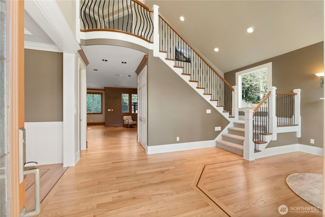 19665 SE 310th Pl, Kent, WA 98042 - entrance foyer featuring light wood-style floors, stairway, a towering ceiling, baseboards, and arched walkways