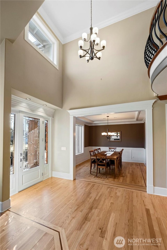 19665 SE 310th Pl, Kent, WA 98042 - dining area with a chandelier, ornamental molding, light wood-style floors, a high ceiling, and baseboards