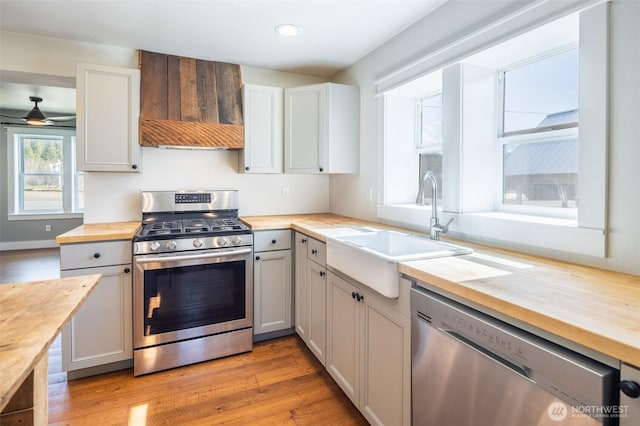 308 S 1st St, Roslyn, WA 98941 - kitchen with a sink, butcher block countertops, light wood-type flooring, custom range hood, and appliances with stainless steel finishes