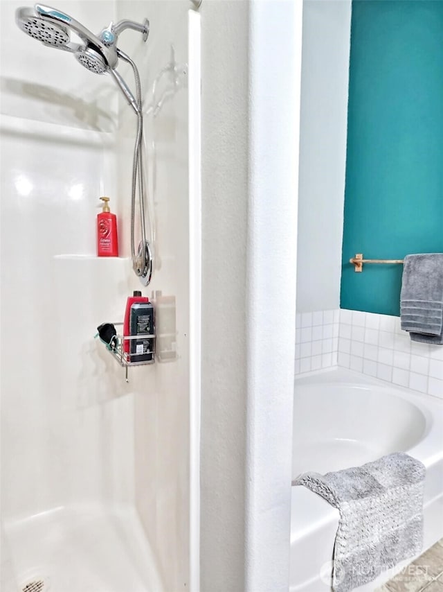 bathroom featuring a garden tub and a shower stall