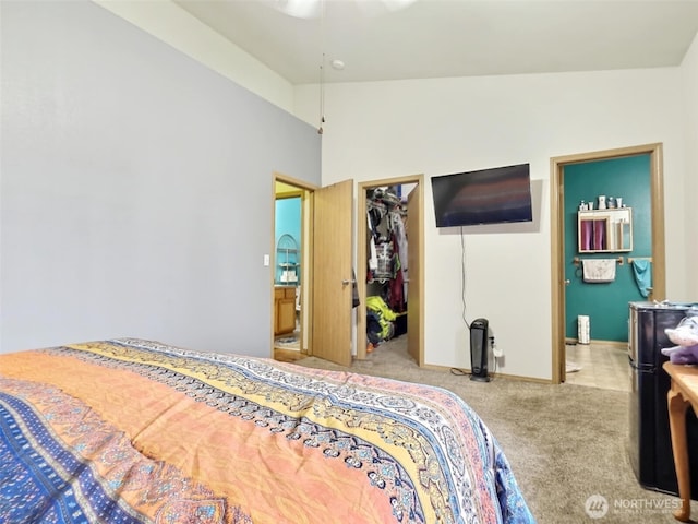 bedroom featuring a walk in closet, carpet, a closet, and connected bathroom