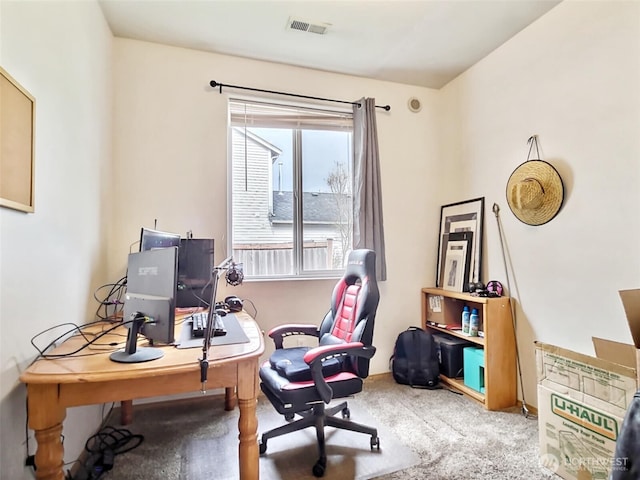 office area featuring visible vents and carpet flooring