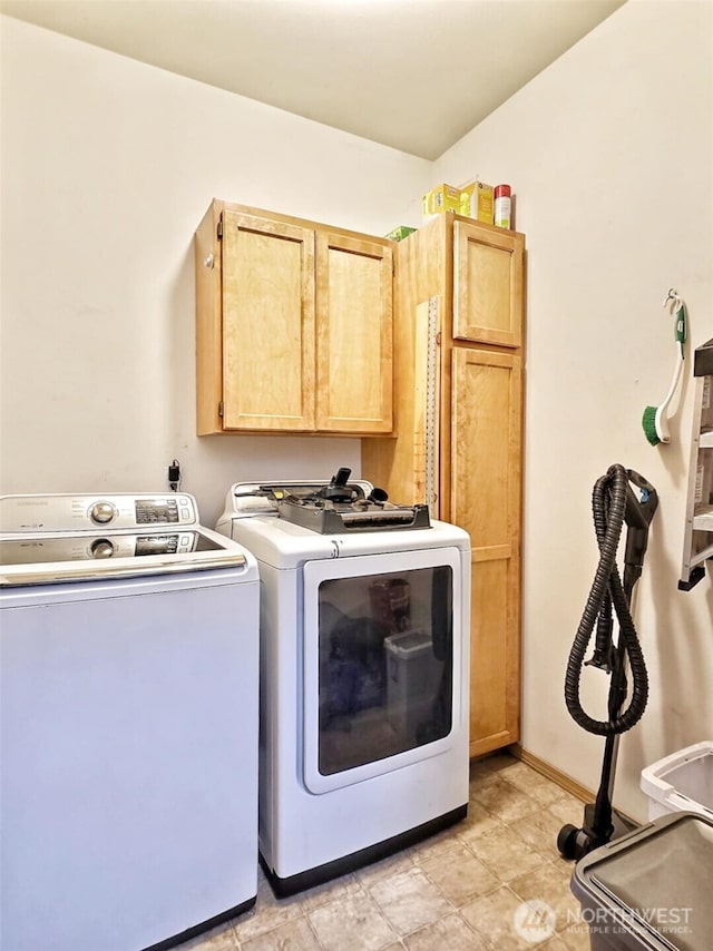 laundry room with baseboards, cabinet space, and washing machine and dryer