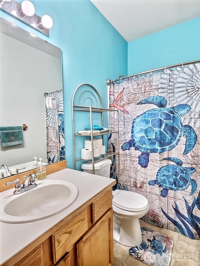 bathroom featuring tile patterned flooring, toilet, vanity, and a shower with curtain