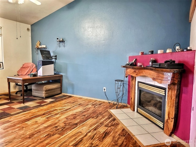 office with wood finished floors, a fireplace, baseboards, and ceiling fan