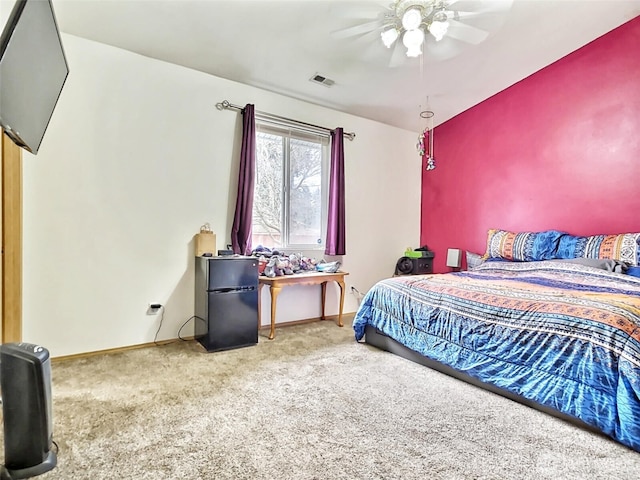 carpeted bedroom featuring visible vents, a ceiling fan, fridge, and baseboards