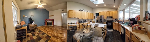 kitchen featuring a ceiling fan, light brown cabinetry, black appliances, under cabinet range hood, and lofted ceiling with skylight