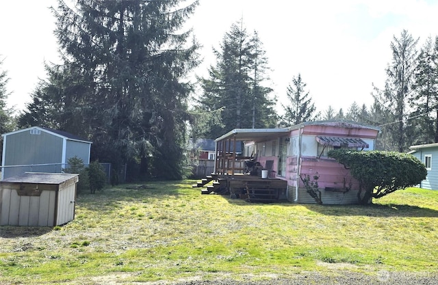 view of yard with an outbuilding, a wooden deck, and a storage shed