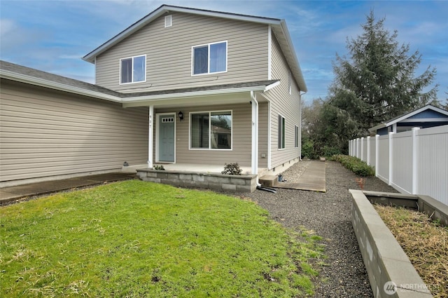 view of front of house with a front yard, fence, and covered porch